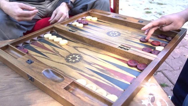 Board of backgammon and hands of two players