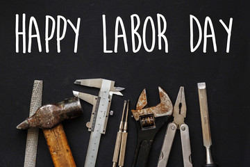 happy labor day text sign. Working tools on black background top view. set instruments for hand...