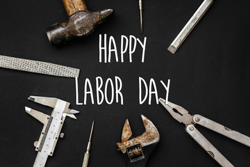happy labor day text sign. Tools for repairing and renovation concept on black background top view....