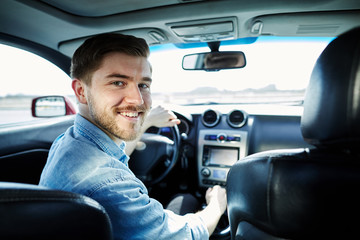 Happy man sitting in car