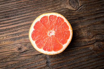 Fototapeta na wymiar Red grapefruit on an old wooden table