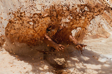 Mud race runners, jump into dirty water with foam