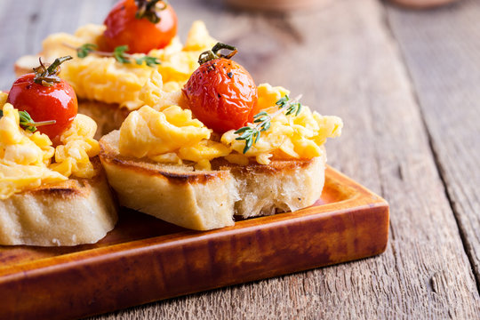 Bruschetta with scrambled eggs and roasted cherry tomatoes