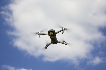 The drone flying over the blue sky background to take a photo / The flying drone on the sky