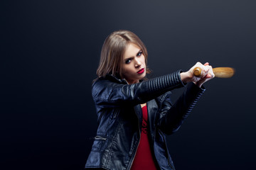 Portrait of young beautiful woman in a leather jacket, red underwear Looks into the camera and beats a wooden baseball bat