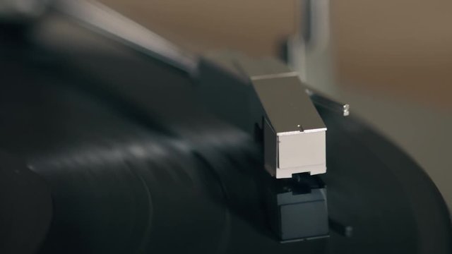 Close up 4k movie of a record player playing a vinyl black record.