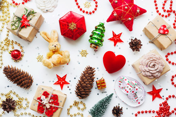 Christmas and New Year background with decorations. Gifts in craft paper, pine cones, red hearts and confetti. Flay lay, top view.