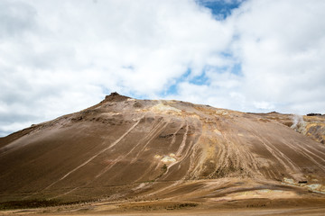 Mudpot in the Namafjall geothermal area, Iceland - area around boiling mud is multicolored and cracked