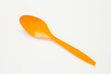Orange spoon on white canvas background