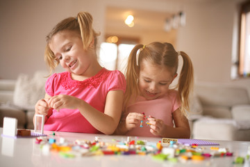 Fototapeta premium Girls playing at home. Girls playing with Bricks at home.