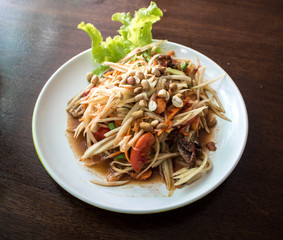 Papaya salad on wooden table (Som tum Thai). Look from top to bottom.