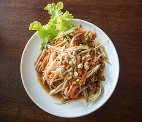 Papaya salad on wooden table (Som tum Thai). Look from top to bottom.