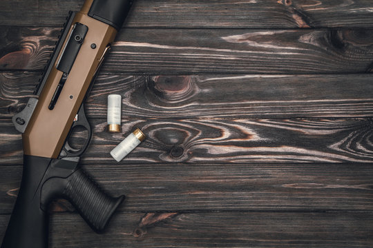 Silver shotgun on a wooden background
