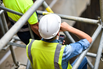 Workers inspecting construction works on a scaffold