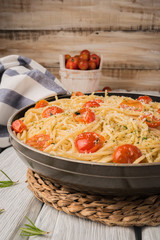 Spaghetti pasta with tomatoes and parsley on wooden table