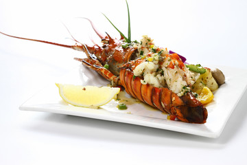 Stir-fried Lobster with Garlic & Butter Sauce on white square porcelain plate Isolated on white background with shadow Tail Side view, Luxury Seafood. Selective Focus.