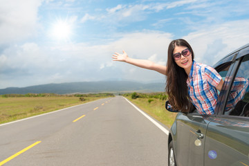 female traveler in car window wearing sunglasses