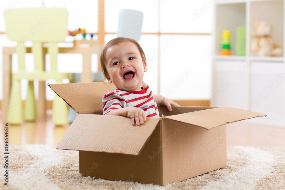 Wall mural pretty baby infant boy sitting inside box