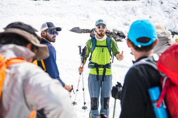 A team of climbers led by a guide discusses the upcoming ascent