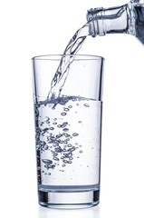 Pouring water into glass on white background