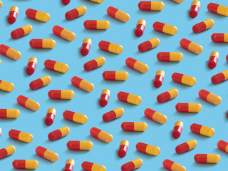 Pattern of red yellow pills on light-blue background