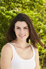 Naklejka premium Gorgeous young brunette smiling at camera, outdoors
