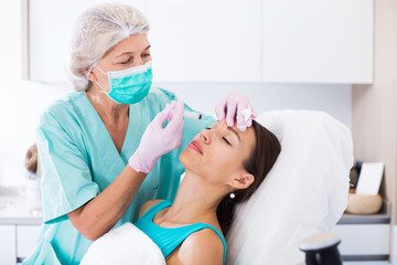 Young woman getting facial injection