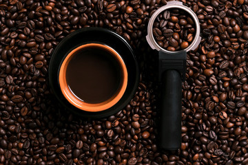 A cup of black coffee with coffee bean as background