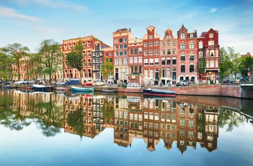 Tuinposter Grachtenpanden van Amsterdam in de schemering met levendige reflecties, Nederland © TTstudio