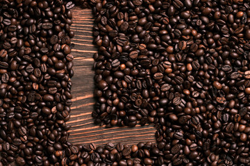 Letter L inscription with coffee bean on the wooden table