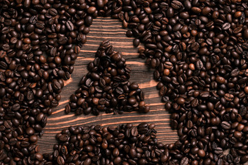 Letter A inscription with coffee bean on the wooden table