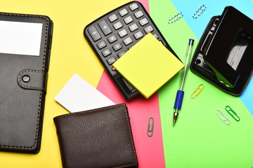 Office tools and wallet isolated on colourful background, top view