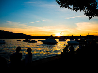 people enjoying sunset at waters edge