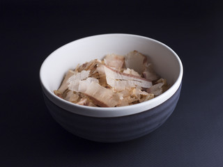 Bonito flakes made from dried, smoked and thinly shaved skipjack tuna flakes. Isolated on black background