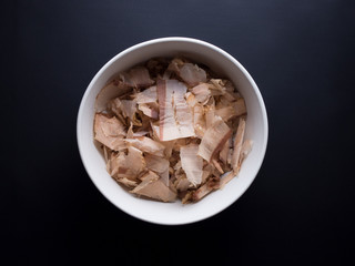 Bonito flakes made from dried, smoked and thinly shaved skipjack tuna flakes. Isolated on black background