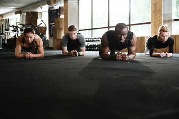 Concentrated sports strong people make plank exercise.