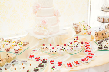 Delicious and tasty dessert table with cupcakes shots at reception closeup