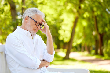 Fototapeta premium thoughtful senior man sitting at summer park