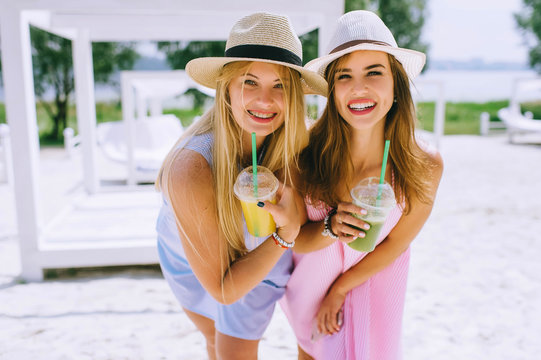 Two beautiful, funny girls, drinking juice