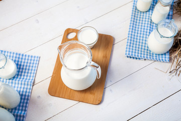 milk and glasses of milk on a wooden rustic table. top view