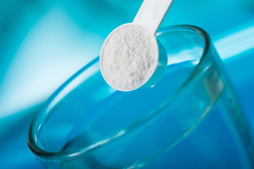 Sport supplement, creatine, hmb, bcaa, amino acid or vitamin - mesure with powder over a glass of...