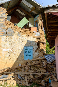 Damaged school in the Kathmandu valley after 2015 Nepal earthquake. The sign reads 'welcome to our school'.