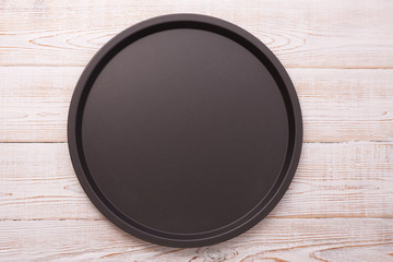 Empty baking tray for pizza on wooden table top view square.