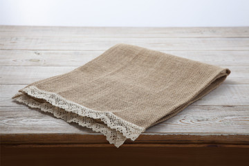 Fototapeta na wymiar Canvas napkin with lace. Burlap hessian sacking on white wooden table background top view