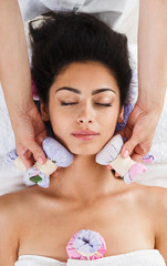 Obraz na płótnie Canvas Woman has herbal ball massage in ayurveda spa wellness center