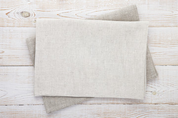 Napkin white. Stack of grey dish towels on white wooden table background top view, mock up.