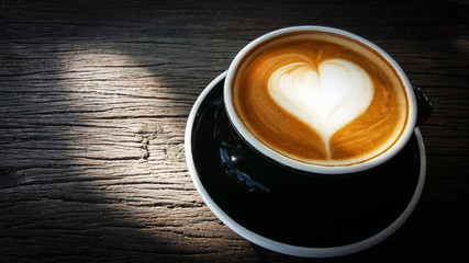 Cup of Latte art with heart shape on old wooden background,top view , mobile phone photography