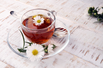 cup of tea with chamomile flowers on rustic background