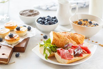 granola with yogurt, sandwiches with meat and avocado, and mini cheesecakes