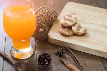 Orange juice in glass with cookies on table, Warm tone in autumn, Lifestyle concept